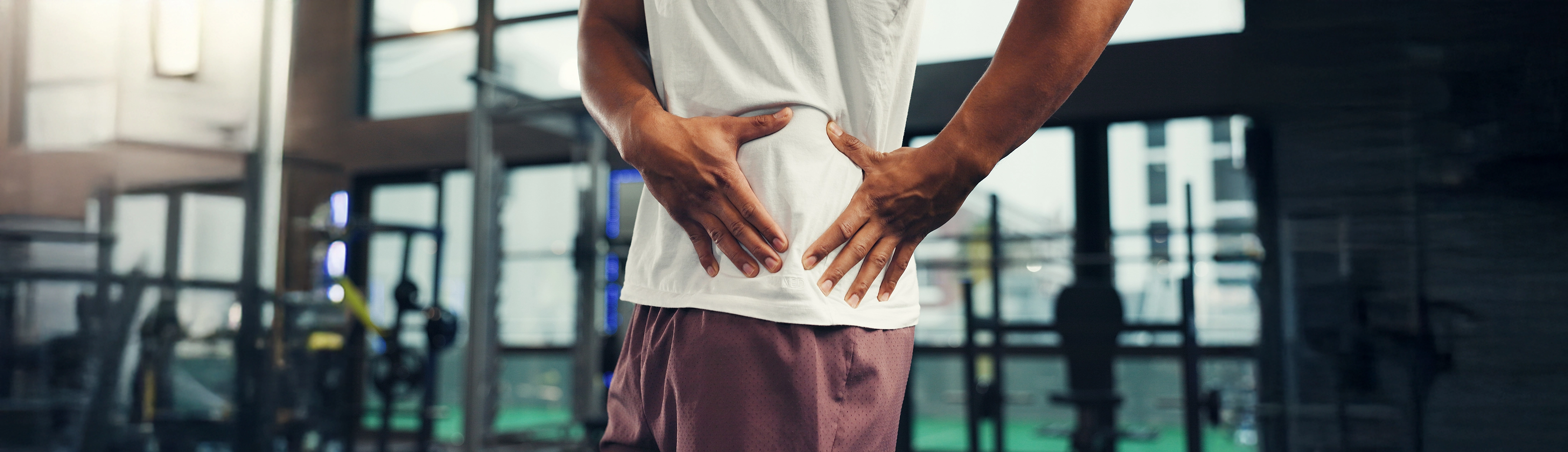 Man in the gym with hip pain during exercise.