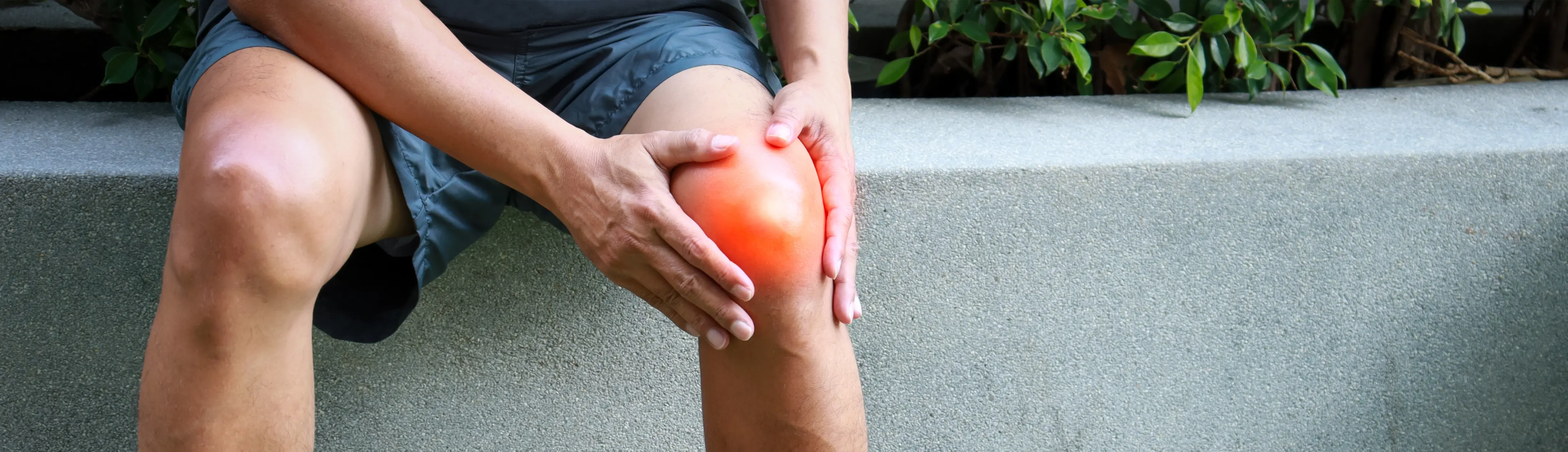 Man holding his swollen knee after exercise due to pain.