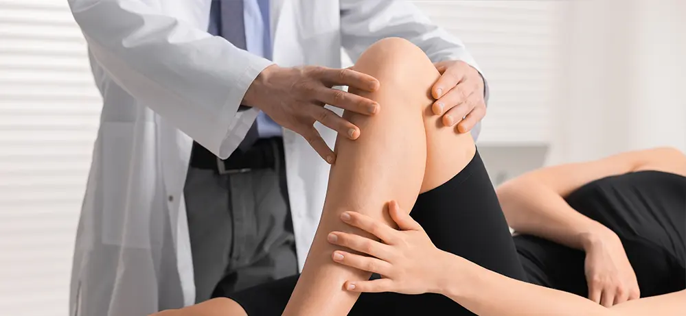 Doctor assessing a patient’s knee.